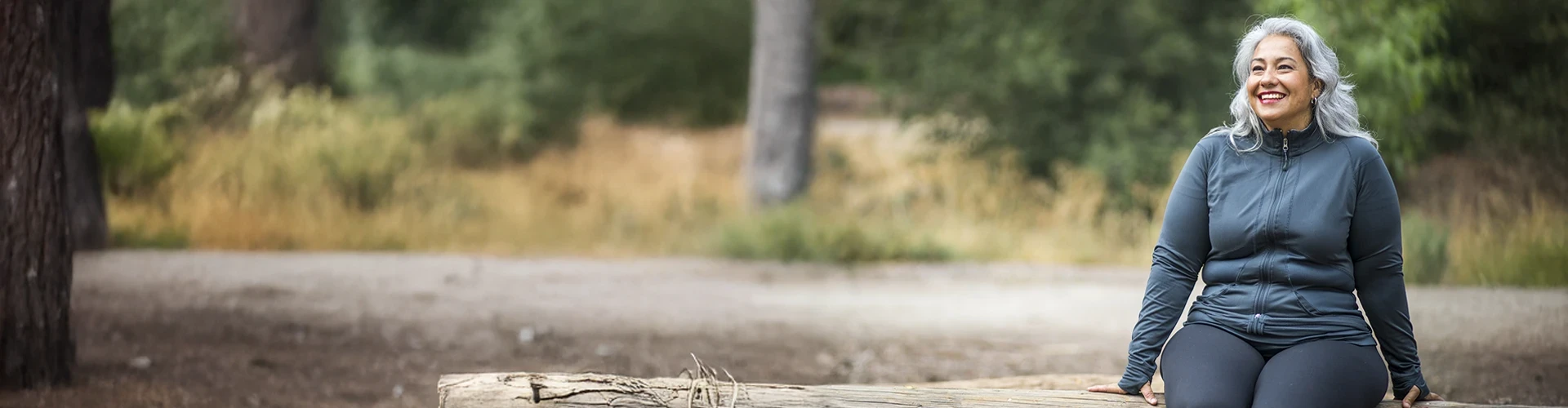 Smiling woman enjoying a wooded trail 