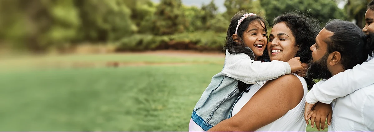 A man, woman and two children play together in a green field.
