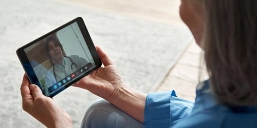 woman holding a tablet and chatting with a doctor